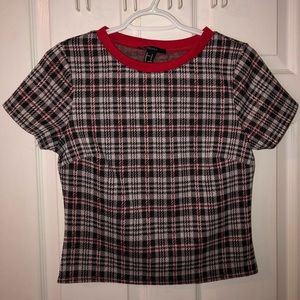 Short sleeve plaid top with red accents.